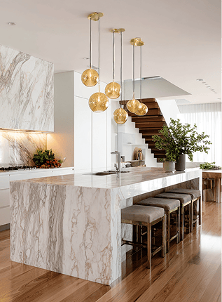 Marble waterfall kitchen island with pendant lights